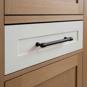Photorealistic 3D rendering of modern black matte cylindrical cabinet pull handle installed on white drawer with light wood cabinetry