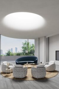 Photorealistic 3D rendering of luxurious modern living room lounge with large circular skylight, curved dark blue sofa, white textured bouclé armchairs, gold coffee tables on circular rug and panoramic city skyline view
