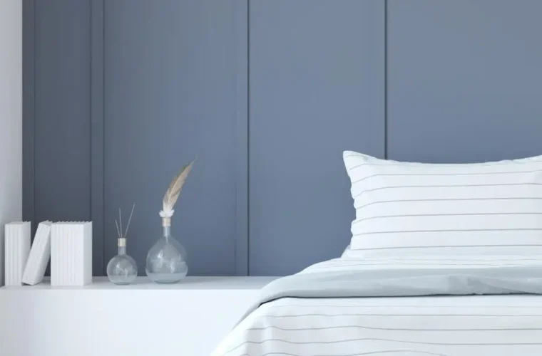 A Minimalist bedroom interior Rendering featuring a blue accent wall, white bedding, and decorative vases